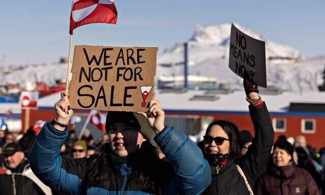 지난 3월15일(현지시각) 그린란드 수도 누크의 미국 영사관 앞에서 ‘그린란드는 그린란드인의 것’이라는 이름으로 열린 집회 모습. 한 시민이 ‘우리는 판매용이 아니다’라는 손팻말을 들고 있다. AFP 연합뉴스