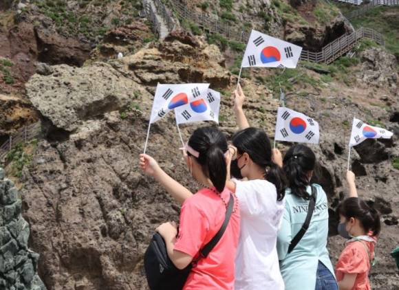 경상북도 울릉군 독도를 방문한 어린이들이 태극기를 들고 기념사진을 찍고 있다. [사진=연합뉴스]