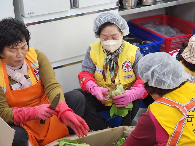 경북 구미에서 '이야기할머니'로 활동하고 있는 배금옥씨가 8일 경북 구미시 사곡동 적십자재난구호센터에서 어려운 이웃들에게 나눠줄 음식을 만들고 있다. 김정석 기자