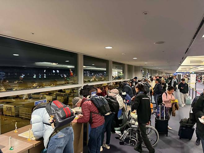 지난 8일 인천국제공항 1터미널에 도착한 외국인들이 검역 통과를 위해 건강상태 질문서를 작성하는 모습. 정부가 입국 절차 간소화를 위해 큐코드를 만들었지만 외국인 대부분은 성가신 절차 때문에 손으로 서류를 작성하고 있다. 사진 독자 제공