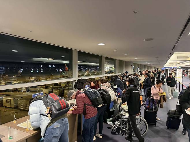 Foreign travelers fill out health declaration forms at Terminal 1 of Incheon International Airport on Jan. 8. Although the government introduced the Q-Code system to streamline entry procedures, most foreigners are still opting for handwritten forms due to the system’s cumbersome process. [JOONGANG ILBO]