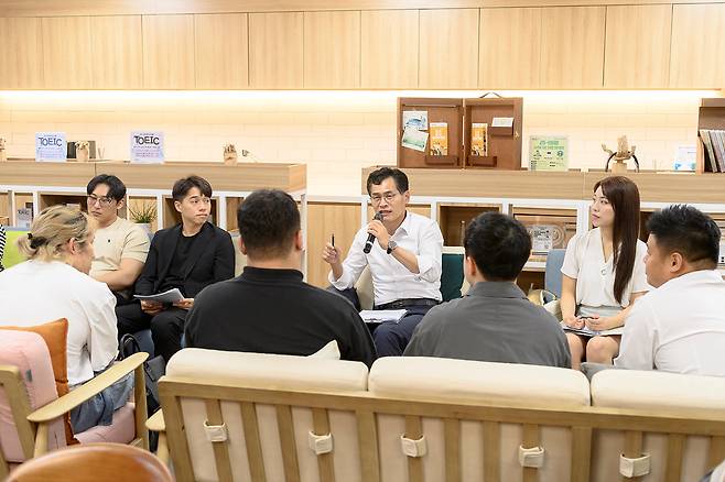실내에서 이기재 양천구청장을 포함한 여러 명이 마주보고 앉아 대화하는 사진이다. 이기재 양천구청장이 마이크를 들고 이야기하고 있다.