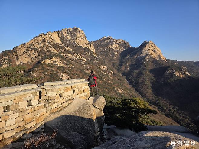노을이 비치는 원효봉의 북한산성 성벽.