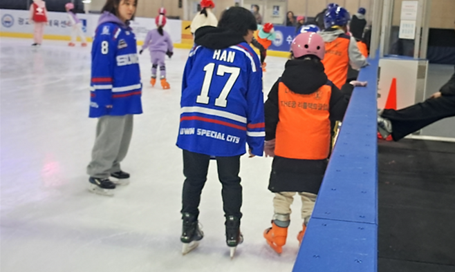 ▲ 수원시청 아이스하키팀 선수들이 아동들의 스케이트 체험을 돕고 있다.