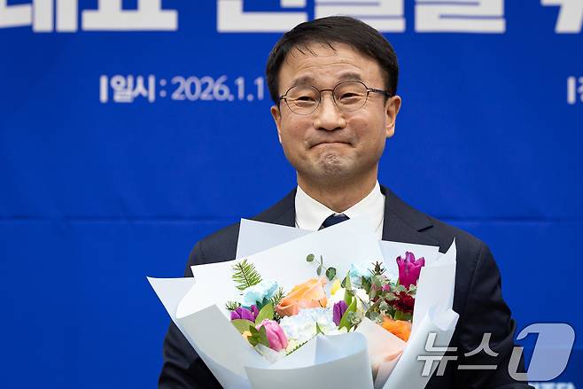 더불어민주당 신임 원내대표로 선출된 한병도 의원이 11일 서울 여의도 국회에서 열린 제22대 국회 더불어민주당 원내대표 선출을 위한 의원총회에서 꽃다발을 들고 있다. 2026.1.11/뉴스1 ⓒ News1 유승관 기자