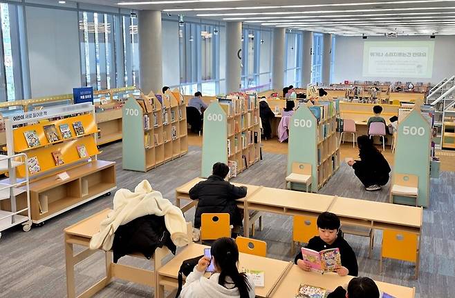 경기 파주시 문산도서관 1층과 2층 사이 경사면 통로를 따라 조성된 어린이자료실에서 이용객들이 책을 읽고 있다. 송상호 기자