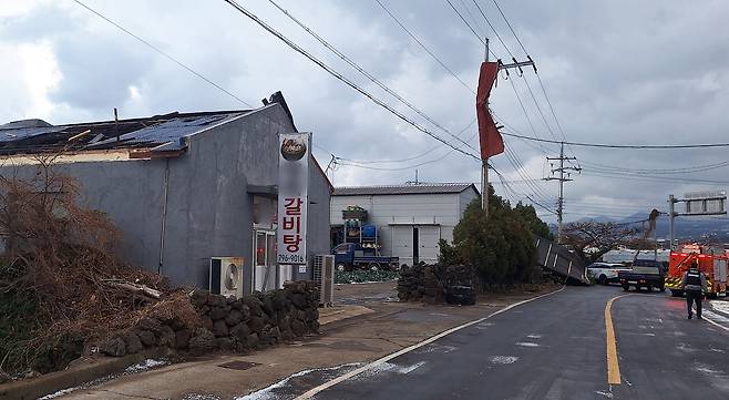 Strong winds tear the roof off a restaurant along a road in Jeju on Jan. 11 as strong wind alerts remain in effect across Jeju Island. [NEWS1]