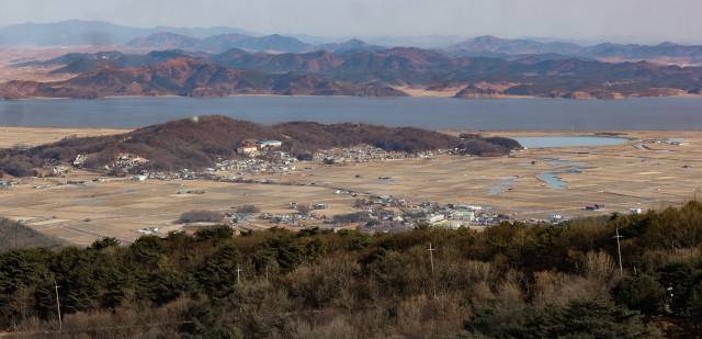 북한이 지난 4일 인천시 강화군 송해면 하도리 일대 상공에서 북쪽방향으로 이동하는 공중목표를 포착해 개성시 개풍구역 묵산리 일대 지점으로 강제추락시켰다고 주장하는 가운데 11일 강화군에서 바라본 송해면 일대(아래)와 강 너머 북한 개풍군 일대(위) 모습. 연합뉴스