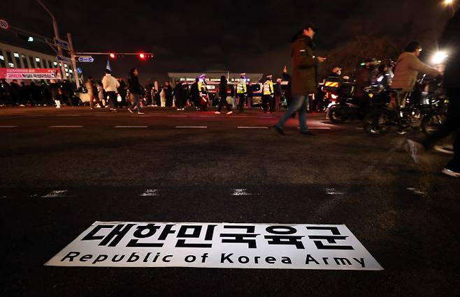 12·3 비상계엄 선포 당시 서울 여의도 국회 앞에 육군 버스에 붙어 있던 현판이 떨어져 있다. (사진=뉴스1)