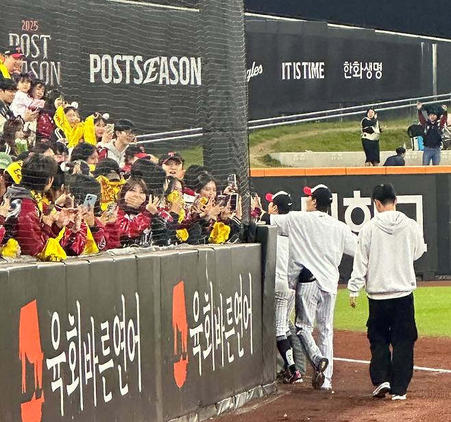 박해민(앞)과 임찬규(뒤)가 10월 31일 대전 한화생명볼파크에서 한국시리즈 우승을 차지한 뒤 그물망을 사이에 두고 팬들과 하이파이브를 하고 있다. 대전=이형석 기자&nbsp;