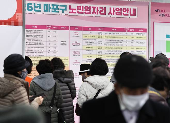 지난해 12월 서울 마포구청에서 열린 노인일자리 박람회에서 노인들이 참가업체 모집요강을 살펴보고 있다. 뉴스1