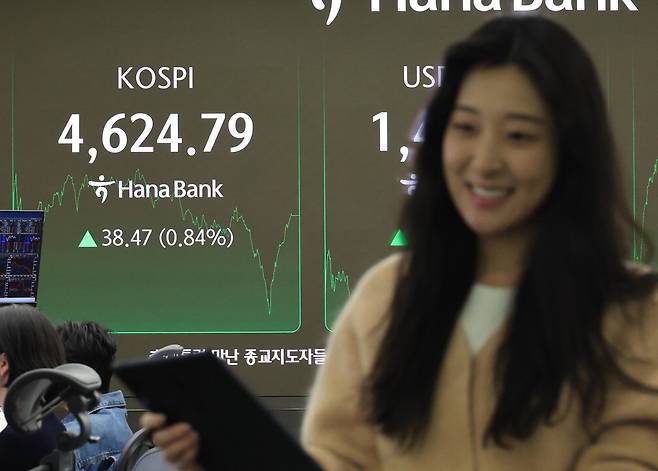 코스피가 종가 기준 사상 처음으로 4600선을 넘어선 12일 서울 하나은행 딜링룸에서 직원이 웃으며 대화하고 있다.  연합뉴스