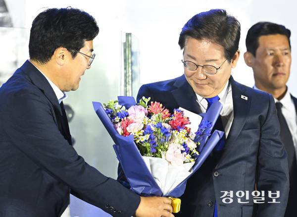 사진은 지난해 6월 4일 새벽 서울 여의도 국회 인근에서 열린 국민개표방송 행사에 참석한 당시 더불어민주당 이재명 대선 후보에게 박찬대 의원이 당선 축하 꽃다발을 건네는 모습. 2025.6.4 /경인일보DB