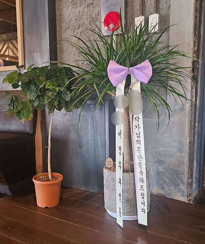 A 서장이 이끄는 경찰서 직원들이 부서 명의로 전시장에 보낸 축하 화분. 사진 독자