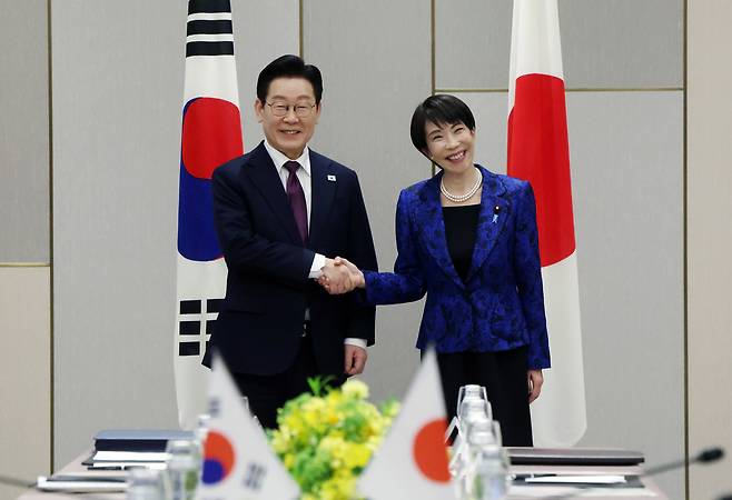 South Korean President Lee Jae Myung (L) shakes hands with Japanese Prime Minister Sanae Takaichi ahead of their talks in the Japanese prefecture of Nara on Tuesday. (Yonhap)