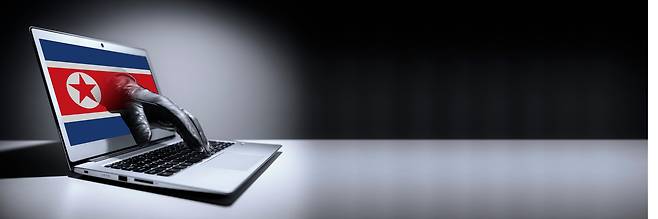 The North Korean flag and a laptop are seen in this file image. [JOONGANG ILBO]