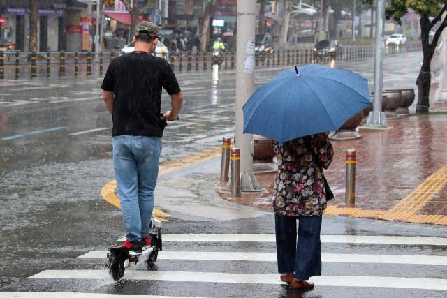 한 시민이 보호장구도 갖추지 않은 채 전동 킥보드를 타며 아슬아슬 곡예 운전을 하고 있다. 뉴스1
