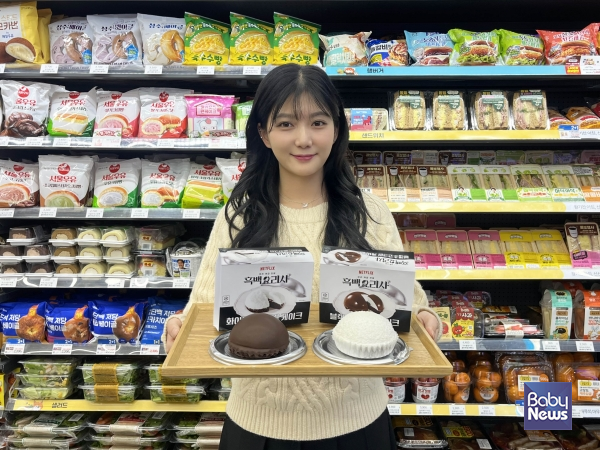 GS25에서 모델이 흑∙백 크림 케이크 2종을 들고 포즈를 취하고 있다. ⓒGS25