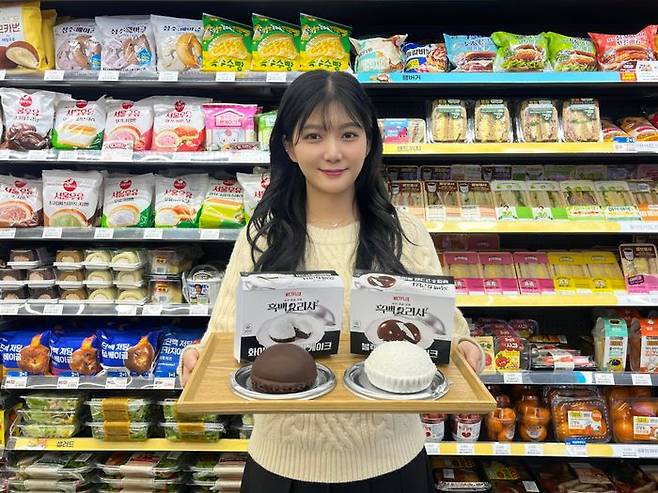 GS25에서 모델이 흑∙백 크림 케이크 2종을 들고 포즈를 취하고 있다.ⓒGS25