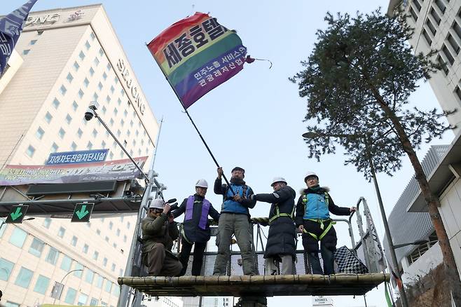 서울 명동 세종호텔 앞 지상 10미터 높이의 교통구조물에서 고공농성을 한 세종호텔 해고노동자 고진수(가운데)씨가 14일 오후 336일 만에 크레인을 타고 내려오고 있다. 김영원 기자 forever@hani.co.kr