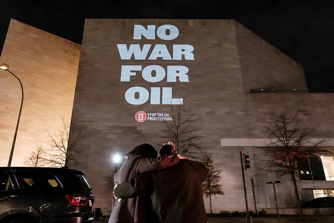 On the evening before President Donald Trump is set to meet with U.S. oil executives to discuss Venezuela, activists staged a large-scale projection opposing oil-driven intervention and the use of U.S. taxpayer dollars to subsidize Big Oil, in Washington on Jan. 8. [AP/YONHAP]