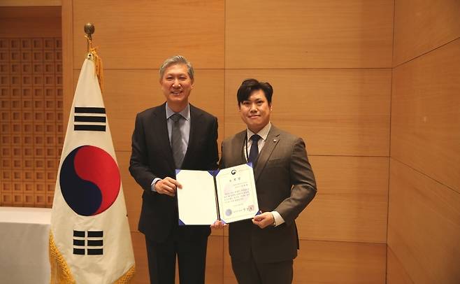 지난 12일 주중국 대한민국 대사관에서 북경지역 비자신청센터 정회윤 총괄 매니저(오른쪽)가 노재헌 주중국대사로부터 법무부 장관 표창을 전수받고 기념촬영에 임하고 있다.