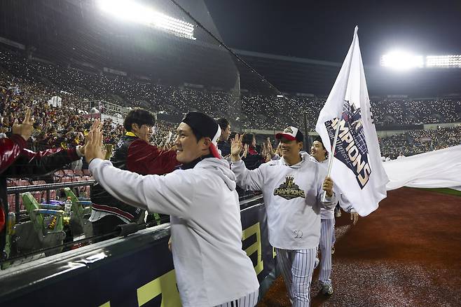 LG 선수들이 지난해 11월 1일 잠실야구장에서 열린 ‘한국시리즈 통합우승 IN 잠실’ 행사에서 그라운드를 돌며 팬들에게 인사하고 있다. 연합뉴스