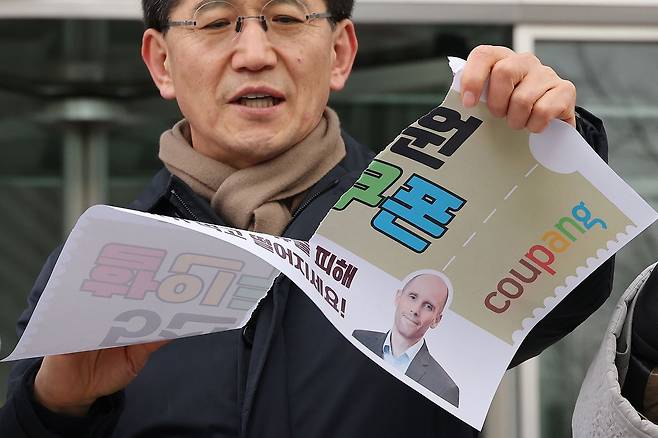 안전한 쿠팡만들기 공동행동 관계자들이 14일 서울 송파구 쿠팡 본사 앞에서 열린 '시민 기만하는 쿠팡 탈퇴, 쿠팡 쿠폰 거부 선언 기자회견'에서 5천원 쿠폰을 찢는 퍼포먼스를 펼치고 있다. 연합뉴스