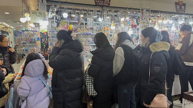 A crowd gathered around a shop selling charms for customization. [WOO JI-WON]