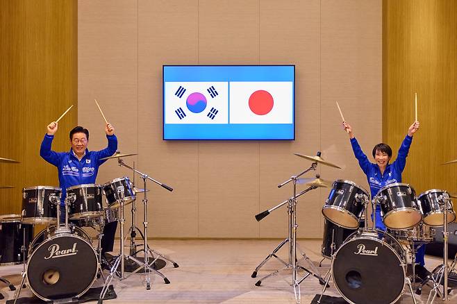 President Lee Jae Myung, left, and Japanese Prime Minister Sanae Takaichi don matching jackets and play a drum duet in Nara, Japan, on Jan. 13. The surprise K-pop drum performance, featuring BTS’s hit “Dynamite,” capped their summit with a show of personal rapport and future-oriented cooperation. [JOINT PRESS CORPS]