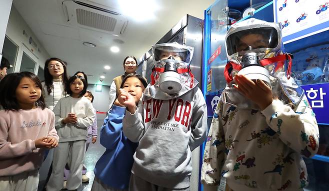 Children are participating in a subway safety drill at the Incheon Metropolitan Office of Education’s Student Safety Experience Center in Namdong District, Incheon, on Jan. 15. They are learning how to use fire evacuation masks. [YONHAP]