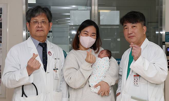 생후 8일 만에 ‘완전 교정술’을 받고 복잡 선천성심장병을 이겨낸 홍이준군과 어머니가 퇴원을 앞두고 유정진 서울아산병원 선천성심장병센터장(왼쪽), 윤태진 소아심장외과 교수와 기념사진을 촬영하고 있다. 서울아산병원 제공