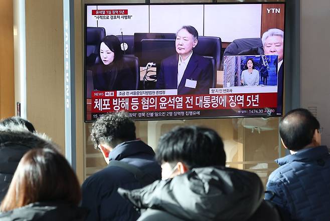 16일 서울역 대합실에서 시민들이 고위공직자범죄수사처(공수처) 체포 방해 등 혐의로 기소된 윤석열 전 대통령에 대한 1심 선고 공판 생중계를 보고 있다. 연합뉴스