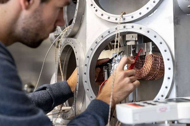 뎀콘 엔지니어가 ASML의 극자외선(EUV) 노광장비에 적용되는 하이테크 메카트로닉스 서브시스템 내부를 점검하는 모습. 진공 챔버 구조 안에서 구리 권선 기반의 전자기 구동·제어 부품을 대상으로 전기적 연결과 정밀 배치를 확인하고 있다. / 사진=뎀콘