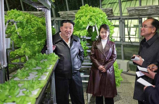 North Korean leader Kim Jong-un, left, and his daughter attend the opening of the Kangdong greenhouse complex on March 16, 2024, in this photo carried by the ruling Workers' Party newspaper Rodong Sinmun. [NEWS1]