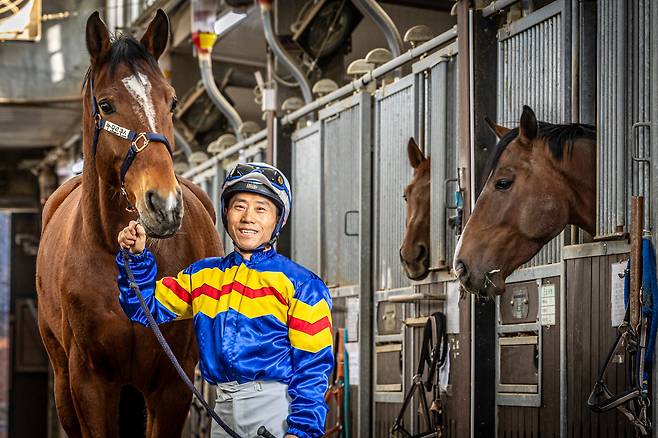 병오년(丙午年) 새해를 맞아 박태종 기수가 경기도 과천 소재 렛츠런파크 마방에서 붉은 말과 함께 섰다. 착용한 기수복은 ‘바다에 떠오르는 태양’을 모티브로 그가 직접 디자인해 30년간 입은 것이다. /이신영 영상미디어 기자