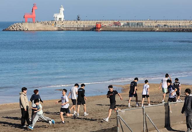 제주시 이호해수욕장에서 전지훈련을 위해 제주를 찾은 선수들이 달리기를 하고 있다.[연합]