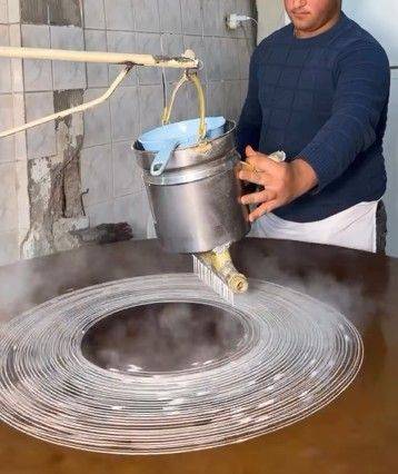 전통 제법으로 카다이프를 만드는 장인. 회전하는 원판 위에 묽은 반죽을 실처럼 흘려 제작한다. 유튜브 캡처