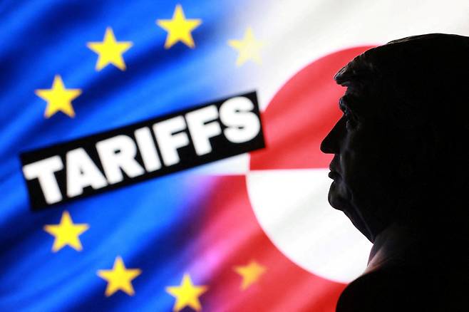 유럽연합(EU)·그린란드 국기와 도널드 트럼프 미국 대통령의 실루엣과 함께 비춰진 'Tariffs(관세).' 대서양 관계에 긴장감이 맴도는 모습을 표현하고 있다. /연합뉴스