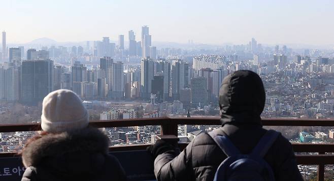 지난 8일 서울 남산 전망대를 찾은 시민들이 아파트가 빼곡한 풍경을 바라보고 있다.   연합뉴스