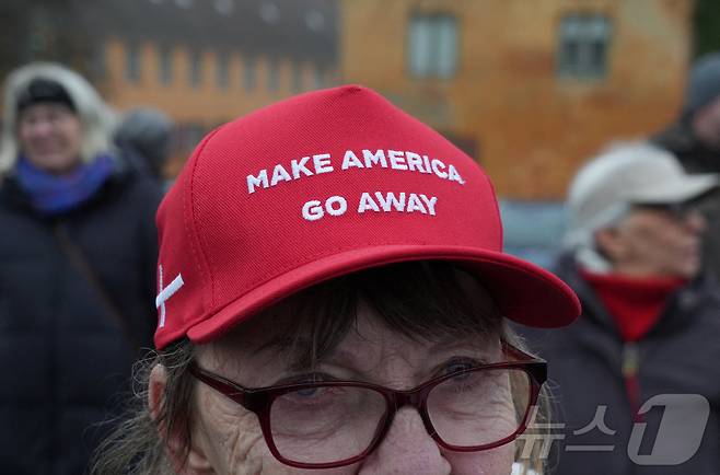 덴마크 수도 코펜하겐에서 미국의 그린란드 병합에 반대하는 시위자가 17일 '미국을 물러가게 하라'(Make America Go Away)라고 쓰인 모자를 쓰고 있다. 2026.1.17 ⓒ 로이터=뉴스1 ⓒ News1 강민경 기자