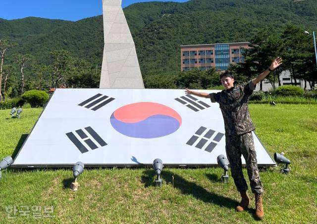 육군 상무부대에서 군 복무를 마친 김종윤 선수가 태극기 앞에서 팔을 활짝 펼쳐 보이고 있다. 유족 제공