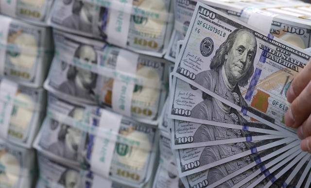 19일 서울 중구 하나은행 위변조대응센터에서 직원이 정리하고 있는 달러화 뭉치가 쌓여 있다. 뉴스1