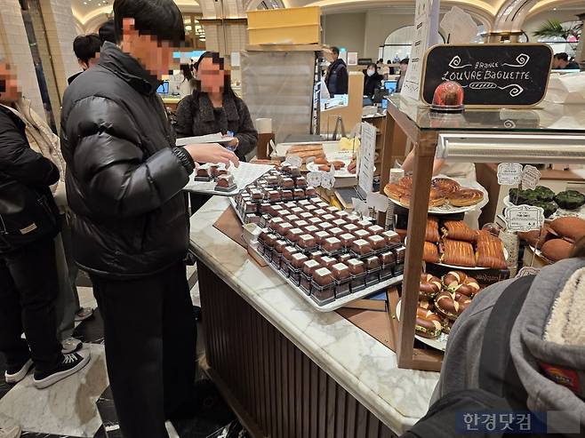 지난 18일 오후 서울 강남의 한 백화점 지하 디저트 전문관 내 두바이쫀득쿠키(두쫀쿠)를 판매하는 매장 앞에서 한 남성이 두쫀쿠를 구매하고 있다. 사진=김대영 기자