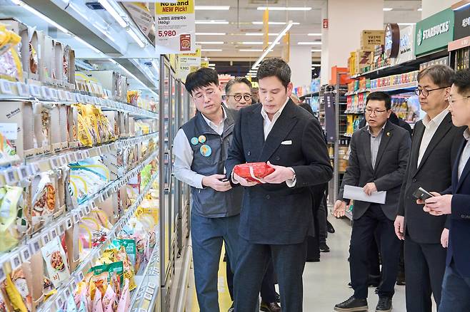 Shinsegae Group Chairman Chung Yong-jin looks at a product sold at a supermarket in Starfield Market's Jukjeon branch in Yongin, Gyeonggi, on Jan. 6 in this photo provided by Shinsegae on Jan. 7. [SHINSEGAE]