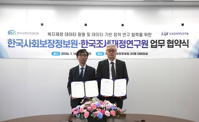 김현준(사진 왼쪽) 한국사회보장정보원 원장과 이영 한국조세재정연구원 원장이 16일 서울 광진구 사회보장정보원 대회의실에서 업무협약을 하고 기념 촬영을 하고 있다.[한국사회보장정보원 제공]