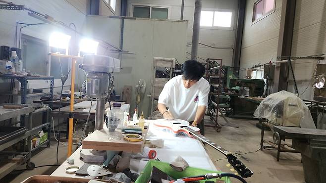 파주에 위치한 길모어에서 2027년 데뷔 50주년을 맞아 출시할 새 기타를 직접 만들고 있는 조용필과 위대한 탄생 기타리스트 최희선. [길모어 제공]