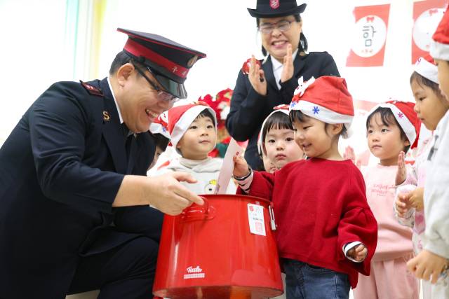 대구 달서구 국공립 아람어린이집에서 열린 '구세군 찾아가는 자선냄비' 행사에서 원생들이 준비한 성금을 자선냄비에 넣고 있다. 연합뉴스