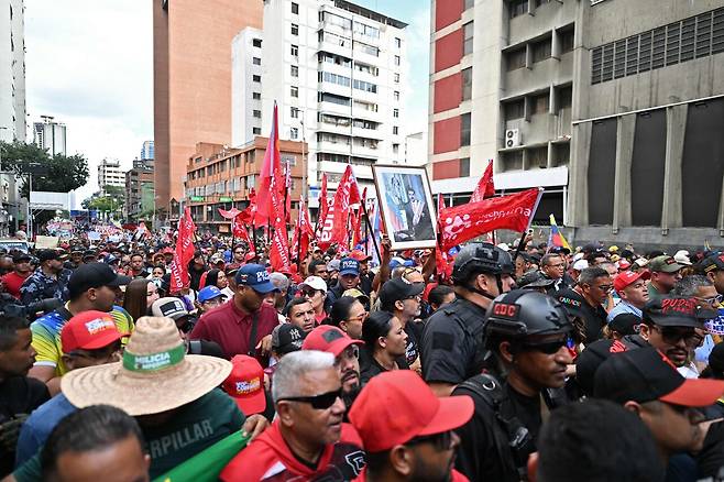 1월4일(현지 시각) 베네수엘라 수도 카라카스에서 마두로 대통령의 지지자들이 그의 초상화를 들고 시위를 벌이고 있다. ⓒAFP PHOTO