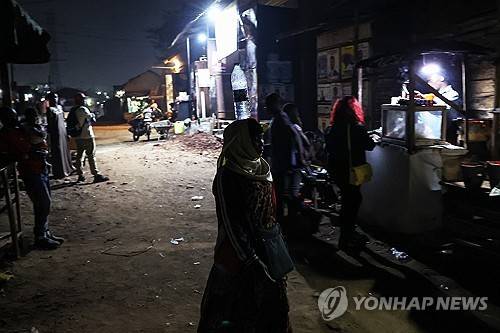 우간다 수도 캄팔라의 풍경 (캄팔라 EPA=연합뉴스) 우간다 대통령 선거 개표 결과가 발표된 다음날인 2026년 1월 18일 밤에 우간다 수도 캄팔라의 거리를 한 여성이 니나가고 있다. (EPA/DANIEL IRUNGU) 2026.1.19.